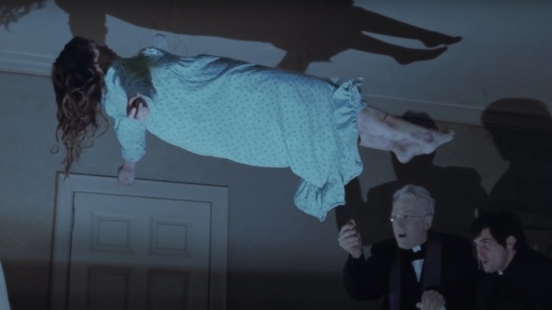 Linda Blair floating in air as priests perform Exorcism in The Exorcist