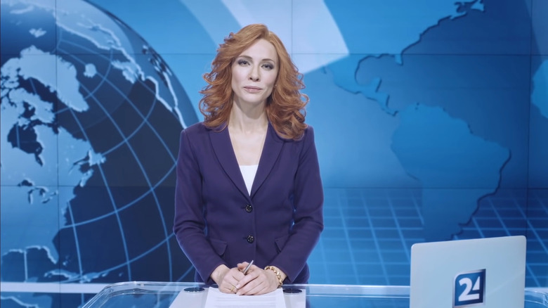 Blanchett in purple suit as news anchor