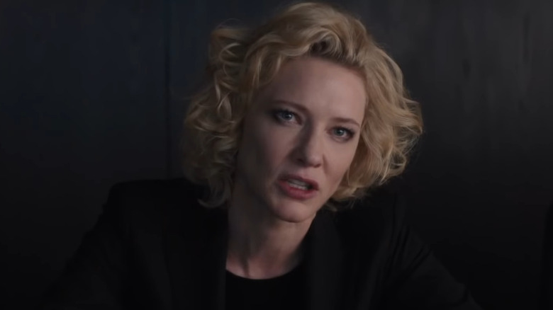 Blanchett leaning forward to talk with blonde curls