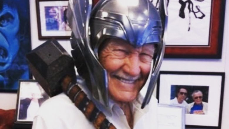 Stan Lee wearing Thor helmet and holding Thor hammer