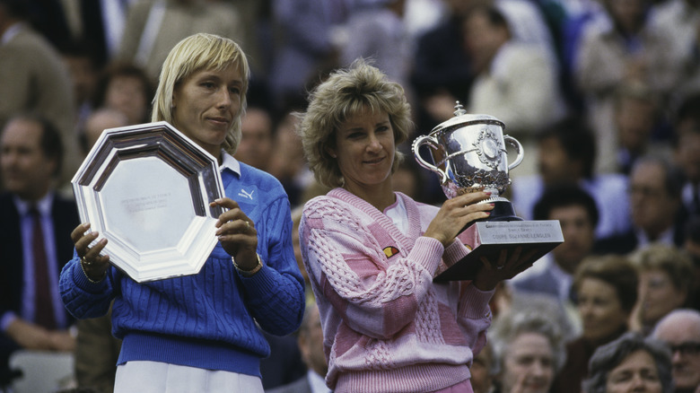 Martina Navratilova and Chris Evert-Lloyd holding trophies