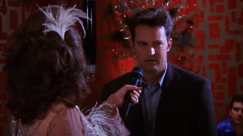 Chandler talking into a microphone