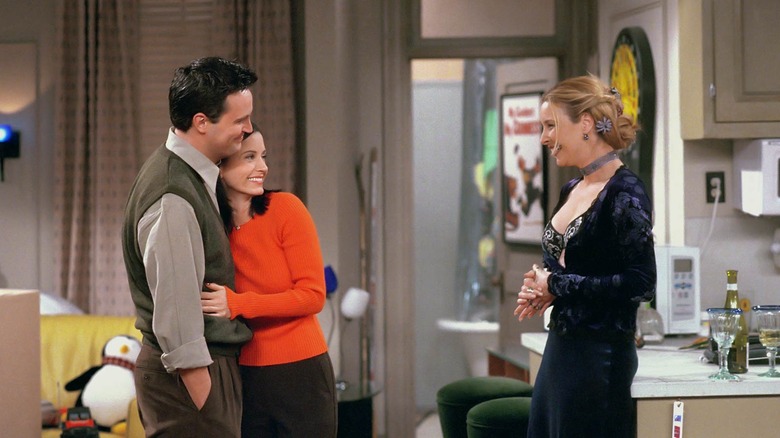 Phoebe smiling at Monica and Chandler