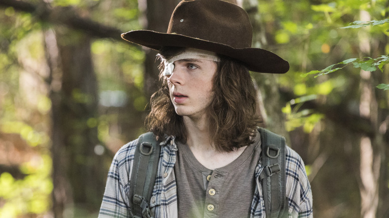 Carl with an eyepatch in a forest in The Walking Dead