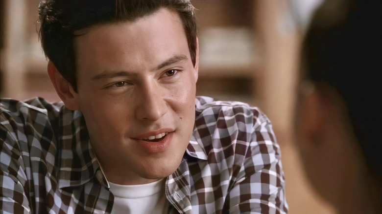 Finn talking at a table in Glee