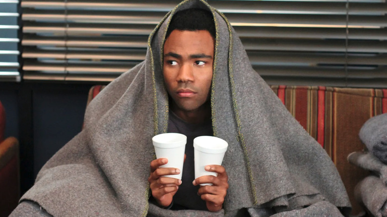 Troy holds two cups of water covered in a blanket