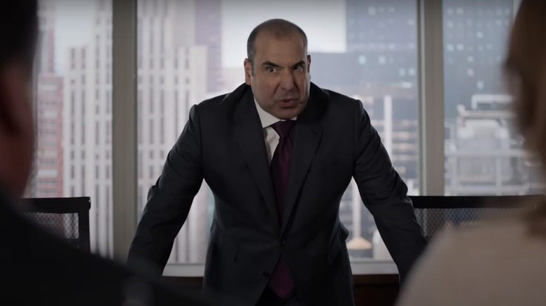 Louis Litt glaring over desk