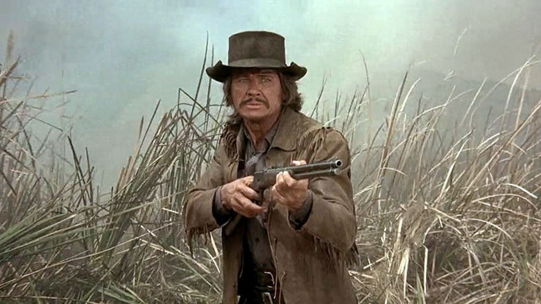 Charles Bronson points gun in weeds