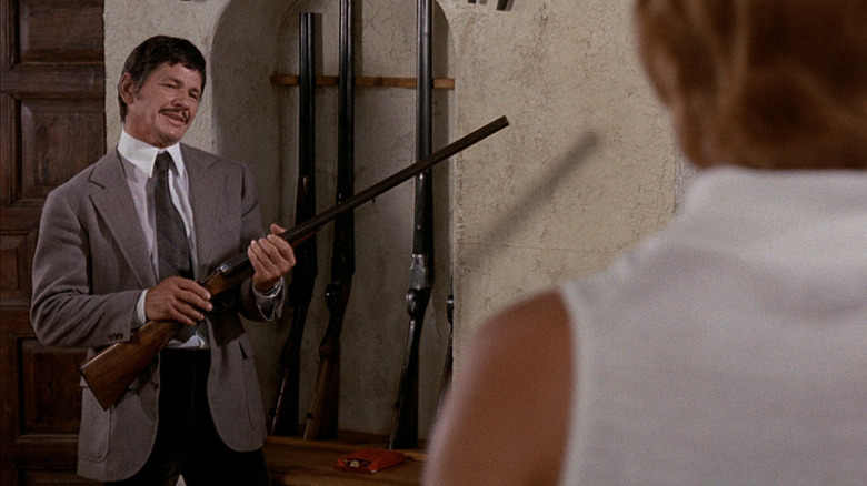 Charles Bronson holds a shotgun