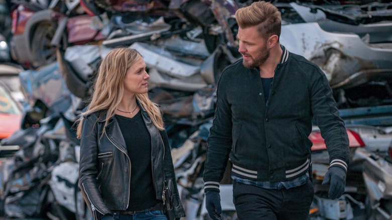 Adam and Hailey talking in a junkyard