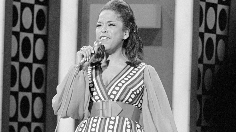 Della Reese talking into microphone