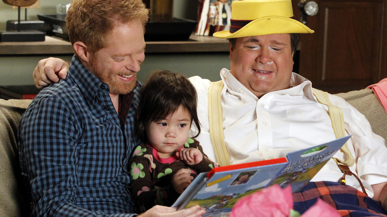 Mitchell, baby Lily, and Cameron reading a book after party (2011)