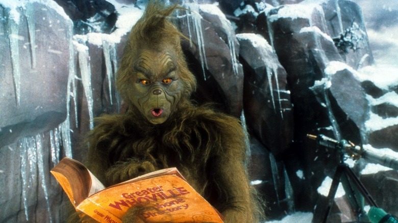 the grinch looking shocked reading book