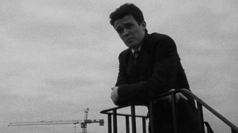 Young man standing against railing