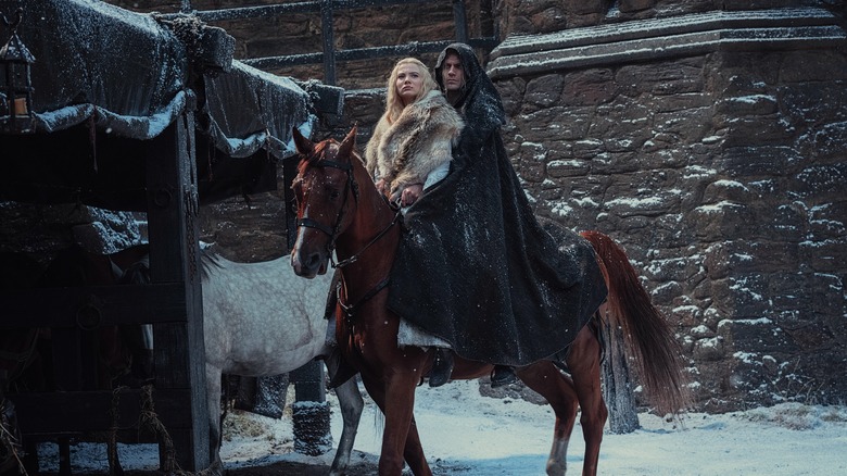 Freya Allan and Henry Cavill on a horse