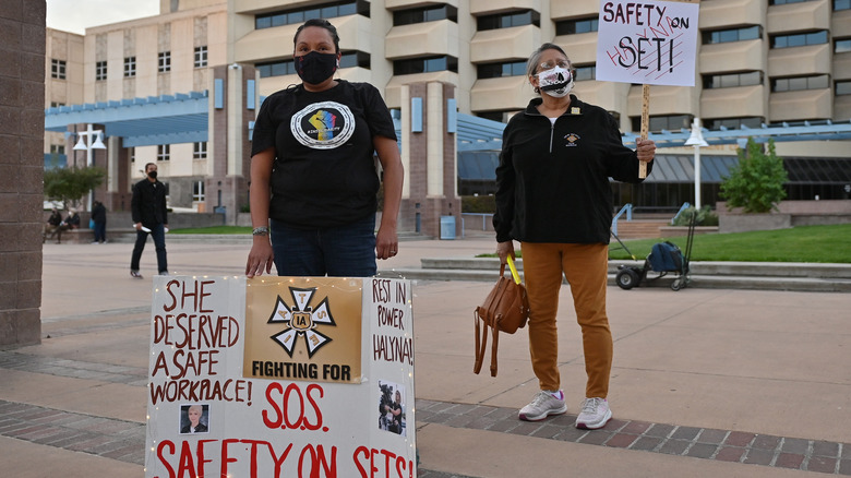 Wynema Chavez Quintana and Jillian Oyenque hold signs during a vigil