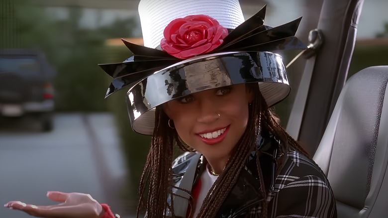 Dionne sitting in car wearing a hat