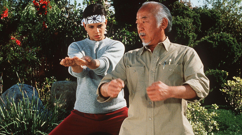 Daniel LaRusso and Mr. Miyagi practice karate in "The Karate Kid" (1984)