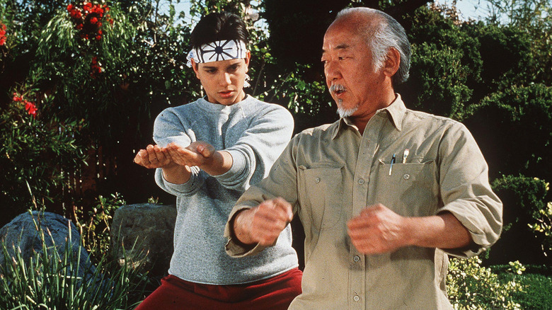 Daniel LaRusso and Mr. Miyagi practice karate in "The Karate Kid" (1984)