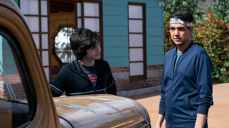 Griffin Santopietro and Ralph Macchio standing by a vehicle