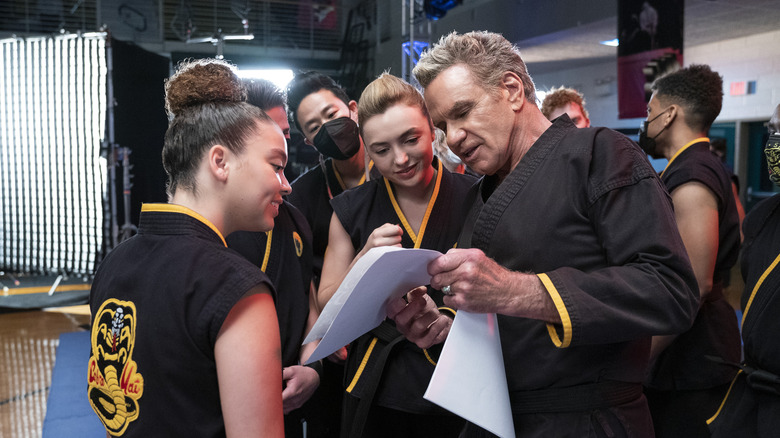 Martin Kove talking with co-stars on the set of Cobra Kai