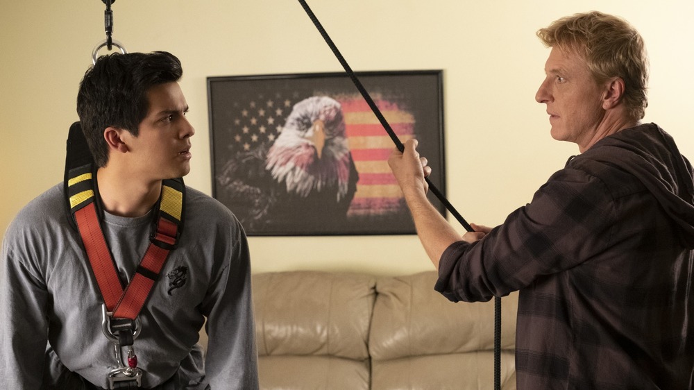 Xolo Mariduena and William Zabka training in a living room