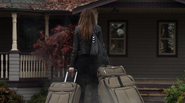 Anne Hathaway holding travel bags