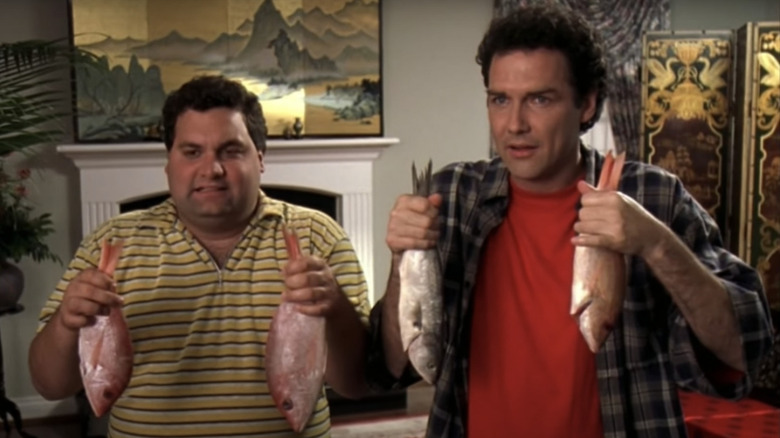 Mitch and Sam hold up pairs of raw fish in "Dirty Work" (1998)