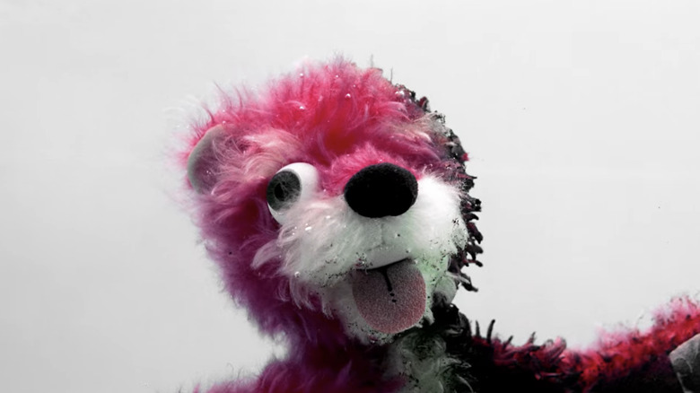 A grotesque stuffed animal smiles