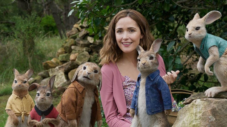 Bea smiling alongside clothed rabbits