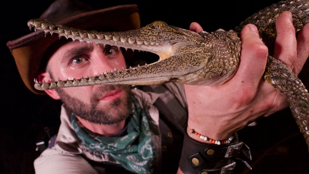 Coyote Peterson holds a crocodile