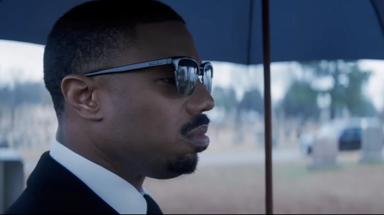 Adonis Creed standing under black umbrella