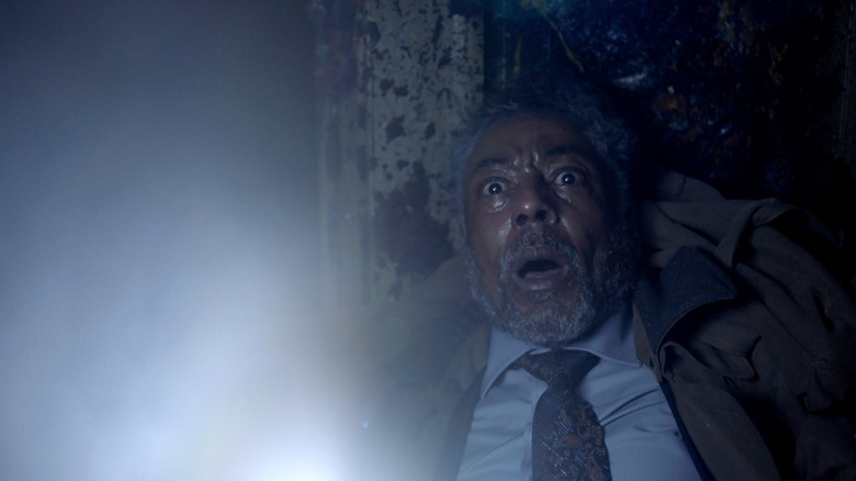 Giancarlo Esposito frightened and holding flashlight