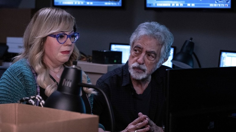 David Rossi and Penelope Garcia sitting at a desk together. Garcia looks visibly shaken