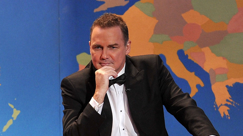 Norm MacDonald sitting at the Weekend Update desk