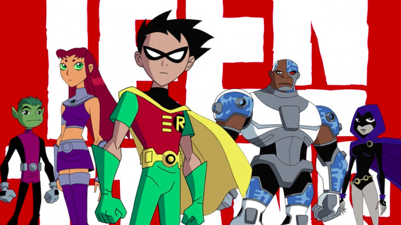 The Teen Titans standing in front of their logo