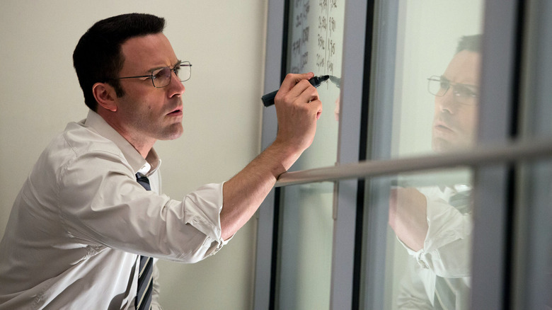 Christian Wolff writes on a glass wall in "The Accountant" (2016)