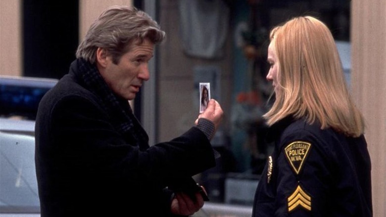 John shows Connie a photo in "The Mothman Prophecies" (2002)