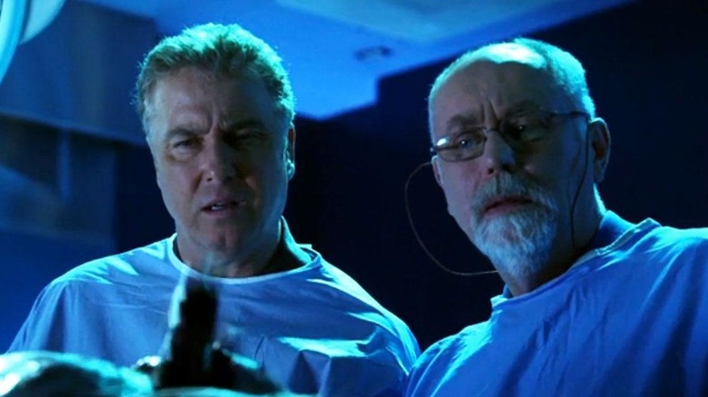 Gil Grissom and Dr. Al Robbins examining a body