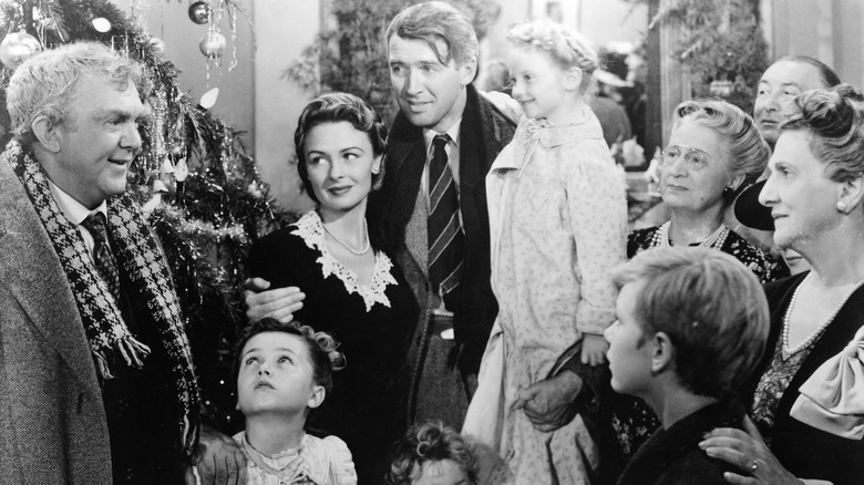 A family hanging out together next to a Christmas tree