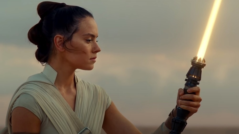 Rey holding lightsaber