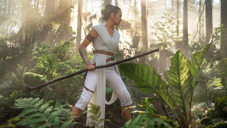 Rey holding staff and in a jungle