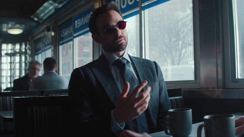 Matt Murdock sitting in a booth in a diner.