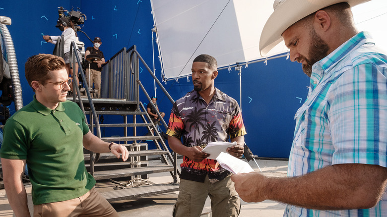 Dave Franco, Jamie Foxx, and J.J. Perry talking on the set of "Day Shift"