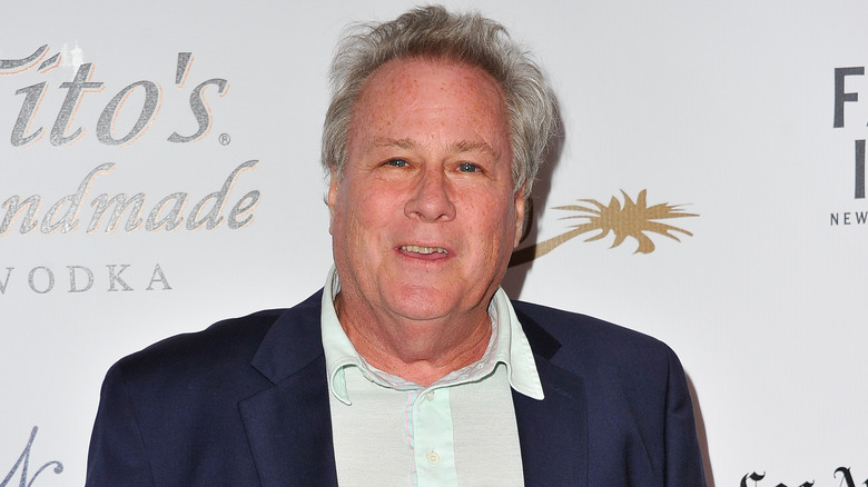 John Heard smiles