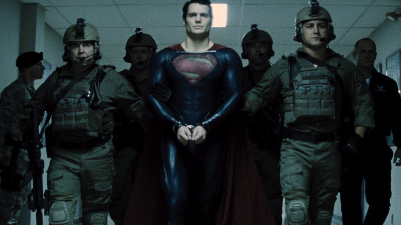 Superman being led by military escort