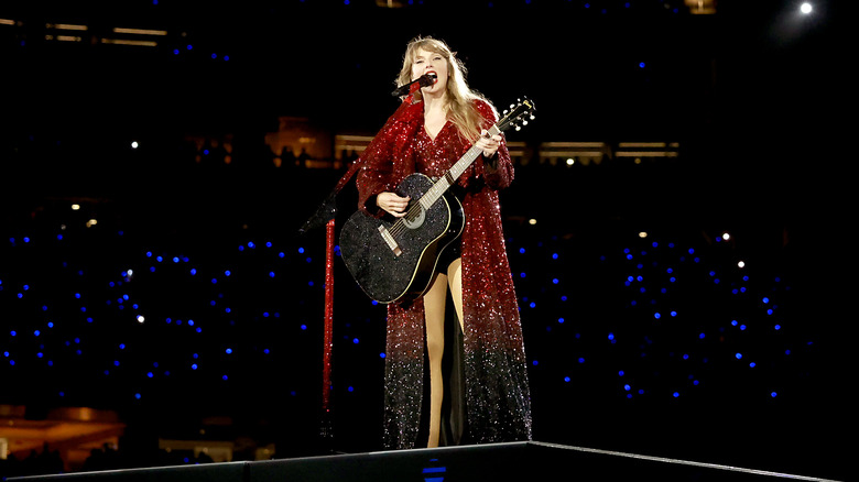 Taylor Swift Eras Tour playing guitar singing