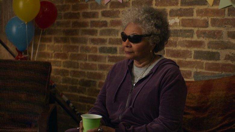 Blind Al sitting beside balloons