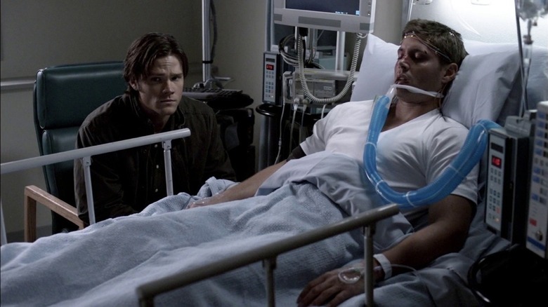 Sam sitting with Dean in hospital bed