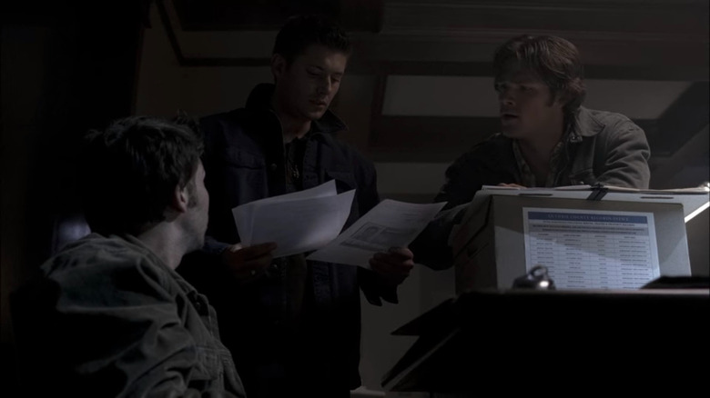 Andy, Dean, and Sam looking at papers